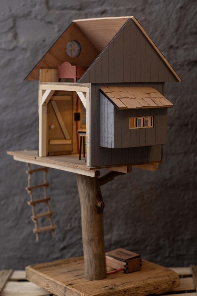 Detailansicht lütten Eiland Baumhaus: Dach mit handgefertigten Schindeln und verbauten Upcycling-Ästen.